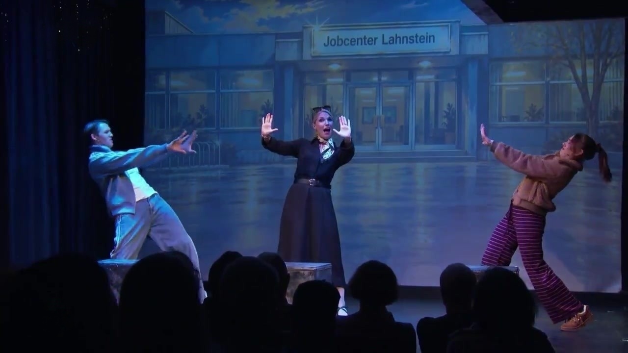 Petra, Maurice und Bibi im Kostüm auf der Bühne vor dem Jobcenter Lahnstein